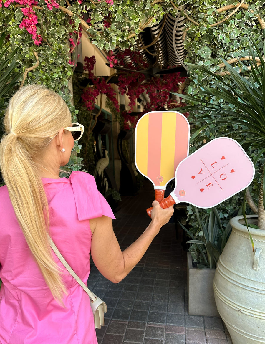 Paddle & Palm Pickleball — Woman holding two painted paddles