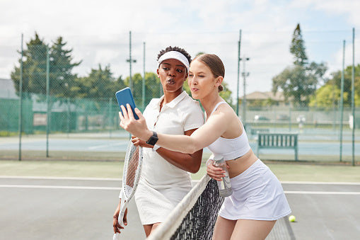 Woman in layered tennis attire transitioning her wardrobe from winter to spring — seasonal styling from The Court Society