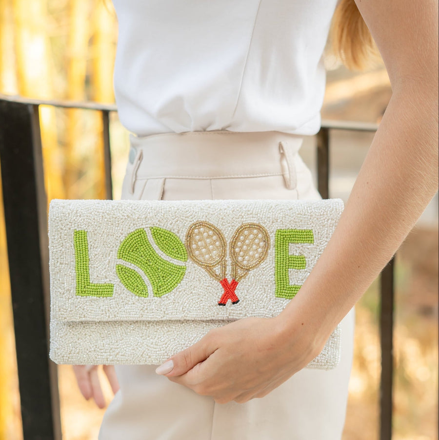 Hand holding a Twine and Love beaded tennis clutch