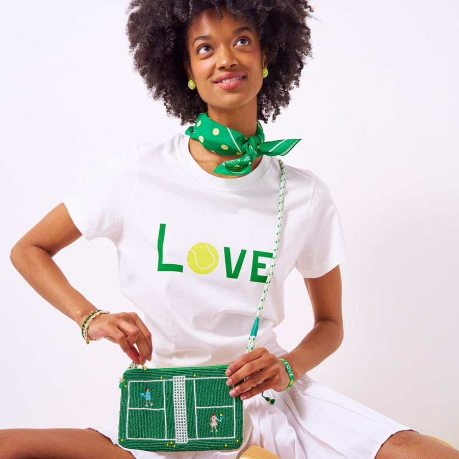INK + ALLOY — Model carrying the clutch with a LOVE tee
